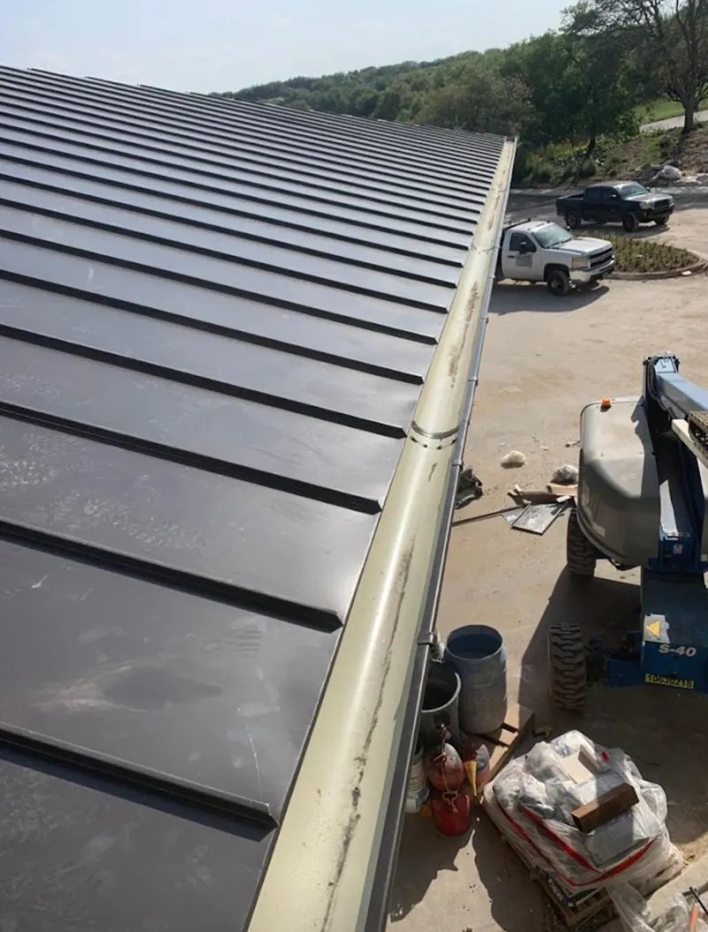 Standing seam panel and gutter detail on a metal roofing jobsite in Holden